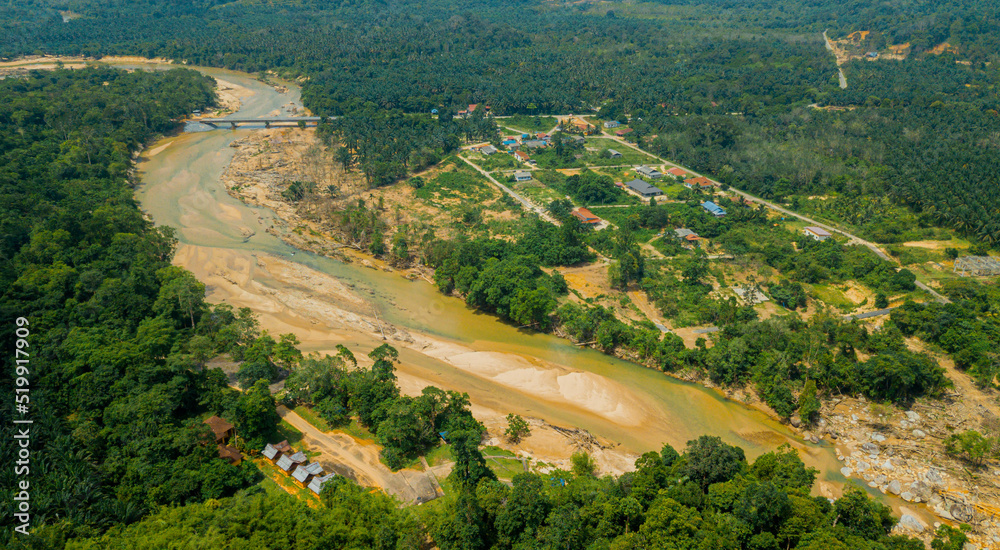 Aerial drone view of rural settlements near a river in Hutan Lipur Belukar Bukit, Kuala Berang, Terengganu, Malaysia.