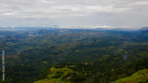 Aerial view of Mountains covered rainforest, trees and blue sky with clouds. Sri Lanka.
