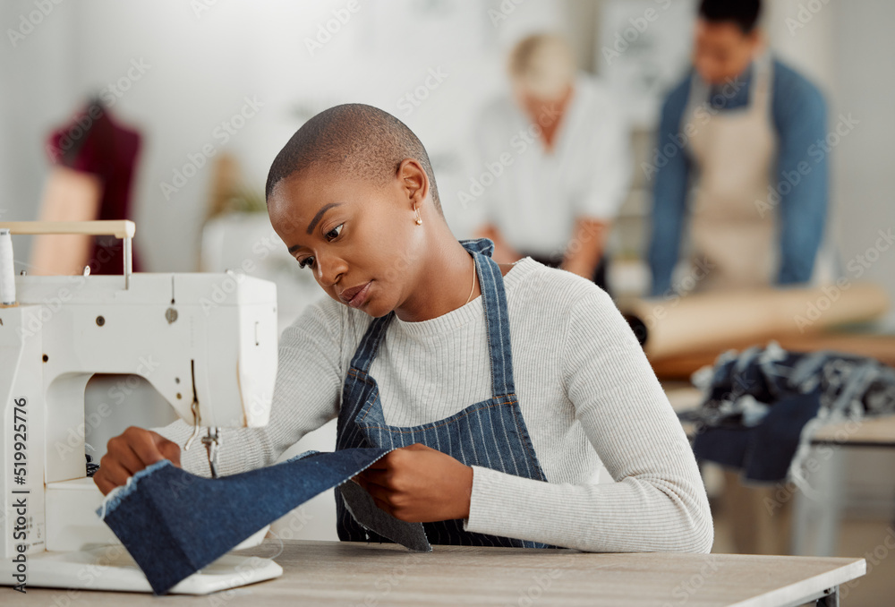 Fashion, design and creative work at a workshop. Young african American  factory worker sewing new, trendy, fashionable clothing of the season.  Black female working on a machine in a busy workplace Stock