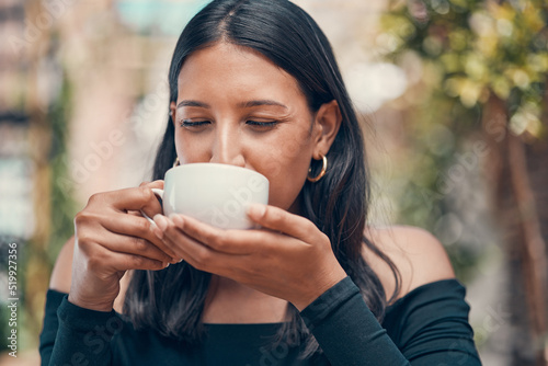 Woman relaxing holding coffee in joy outside. Peaceful, calm and stressless female sipping a mug of tea in a cafe outside. Closeup of carefree lady enjoying a hot beverage in fresh air.