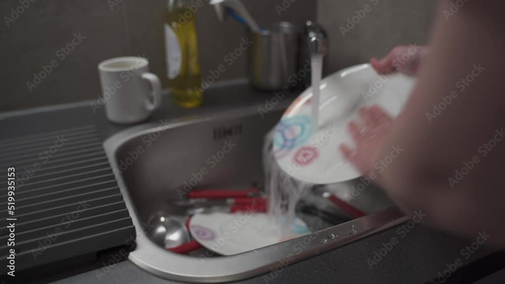 Close up maid housewife washing cleaning dishes in kitchen. Hands of woman washing dishes. Using cleaning soap, person cleaning dishes. Female hands wash dishes in kitchen sink. Household concept Close up maid housewife washing cleaning dishes in kitchen. Hands of woman washing dishes. Using cleaning soap, person cleaning dishes. Female hands wash dishes in kitchen sink. Household concept