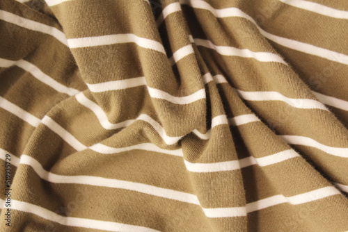 Green ocher crumpled fabric linen with white stripe for creative background. Copy space. Natural textile for wallpaper or design
