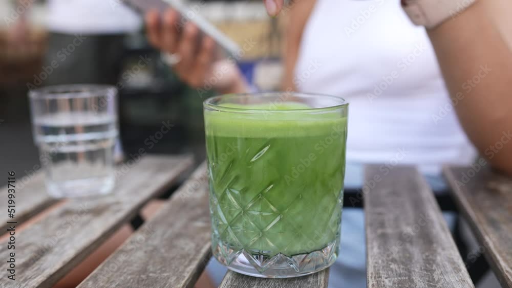 A woman is playing with an ice cube in a glass A woman is playing with an ice cube in a glass