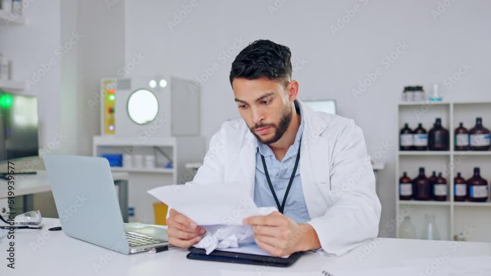 Medical researcher checking, fixing and correcting his work after a mistake with research or data. Frustrated, stressed and angry scientist reading papers, documents and notes for facts in a lab. Medical researcher checking, fixing and correcting his work after a mistake with research or data. Frustrated, stressed and angry scientist reading papers, documents and notes for facts in a lab.