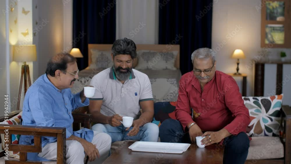 Three middle-aged guys enjoy evening tea together - old friends  celebration  old college friends . A group of school friends spending quality time together - fun times  alumni meet  tea time  Indi...