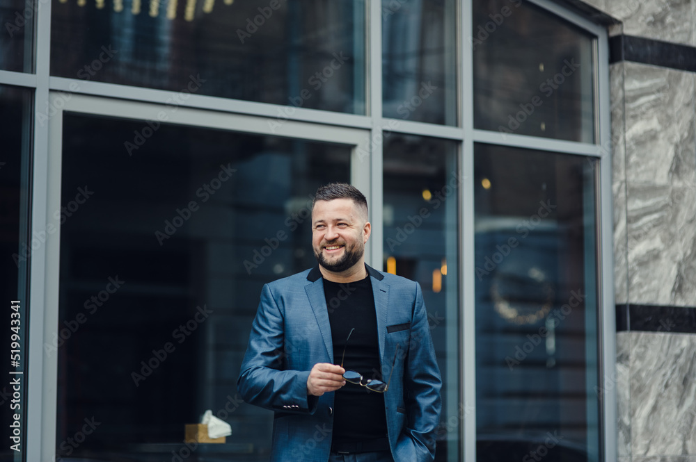 Portrait of handsome confident stylish hipster lambersexual model.Sexy modern man dressed in elegant suit. Fashion male posing in the street background in Europe city at sunset In sunglasses Portrait of handsome confident stylish hipster lambersexual model.Sexy modern man dressed in elegant suit. Fashion male posing in the street background in Europe city at sunset In sunglasses