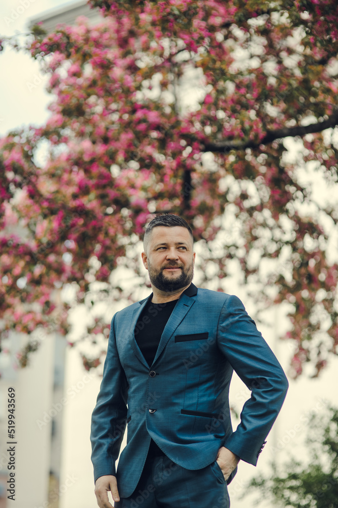 businessman waiting for a meeting in the park.businessman is waiting for a meeting near the office center, looks at the clock businessman waiting for a meeting in the park.businessman is waiting for a meeting near the office center, looks at the clock