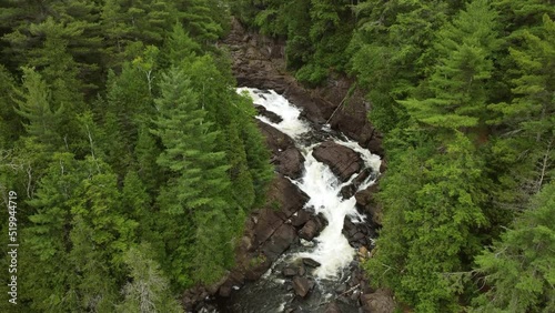 Rising aerial over Oxtongue falls green trees river flowing Algonquin park day photo