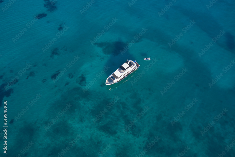White boat on transparent water, top view. White yacht on transparent