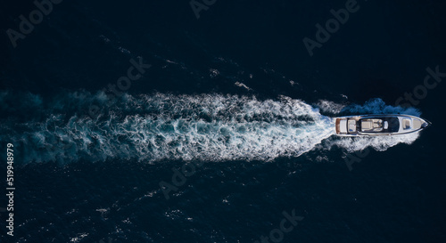 big mega yacht fast movement on dark water in the sea top view. Large super yacht In motion on dark water aerial view.
