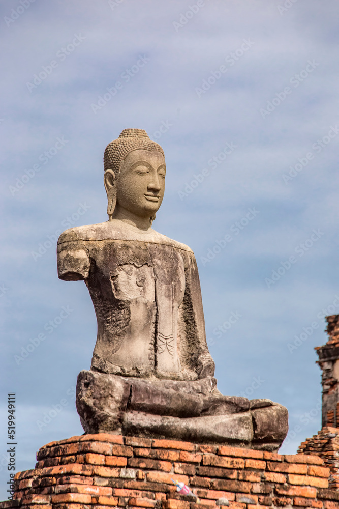 Fototapeta premium The broken Buddha statue in Wat Chaiwatthanaram. A Buddhist temple in the city of Ayutthaya Historical Park, Thailand, on the west bank of the Chao Phraya River. was constructed in 1630 by the king. 