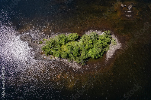Top down view on a small island with green trees in a lake, Connemara, Ireland. Irish landscape scene. Travel and tourism area. Aerial view.