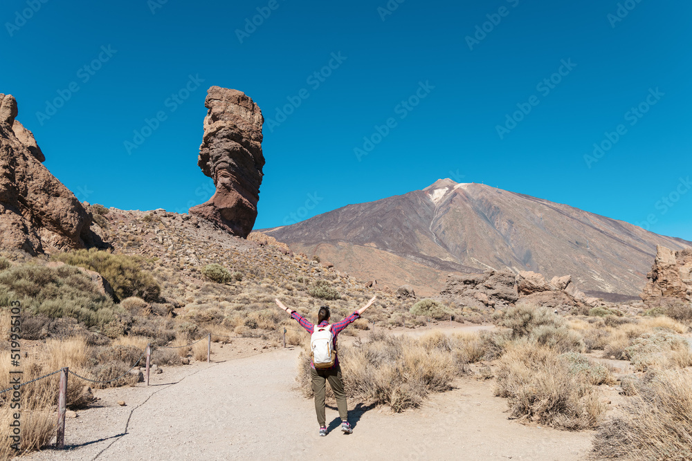 Panoramic view of unique Roque Cinchado unique rock formation with famous Pico del Teide mountain volcano summit in the background on a sunny day, Teide National Park, Tenerife, Canary Islands, Spain