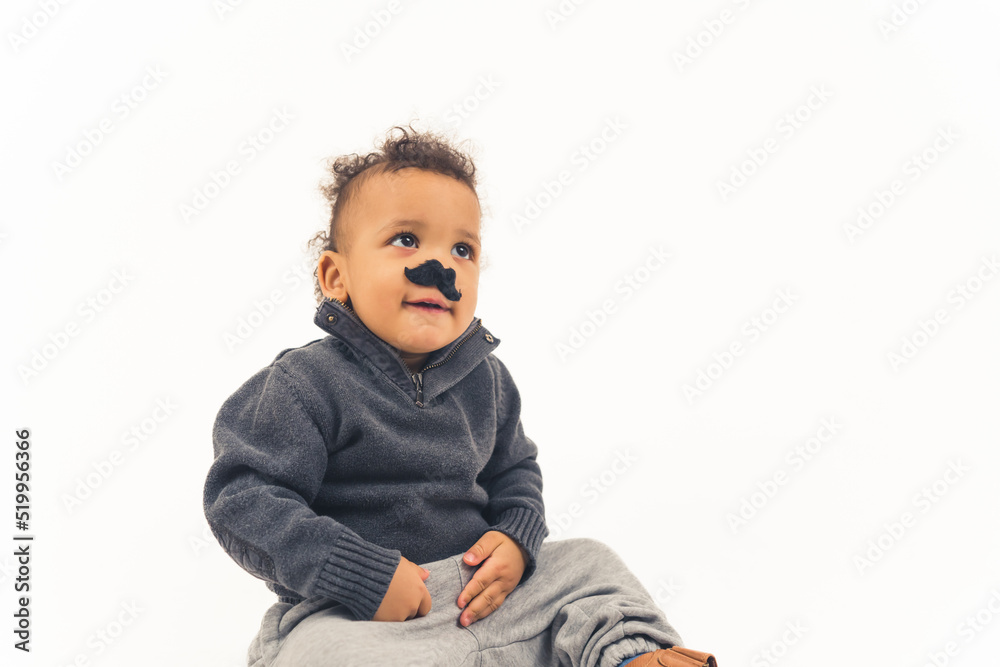 a funny little afro american boy with an artificial mustache sitting on the floor - closeup isolated. High quality photo a funny little afro american boy with an artificial mustache sitting on the floor - closeup isolated. High quality photo