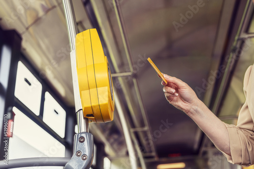 Woman contactless pays for a ticket for public transport in a tram photo