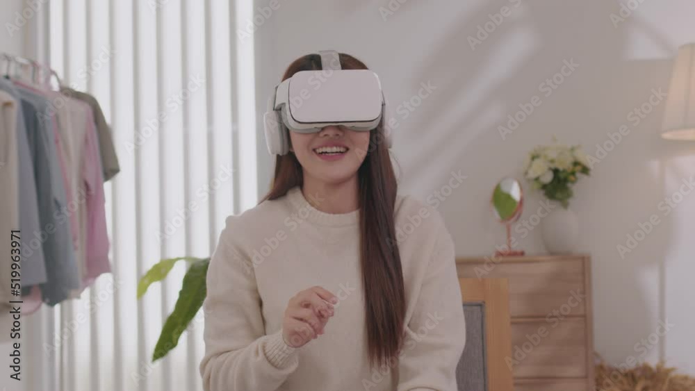 Asian woman wearing virtual reality goggles in modern coworking studio. Smartphone using with VR headset. Asian woman wearing virtual reality goggles in modern coworking studio. Smartphone using with VR headset.