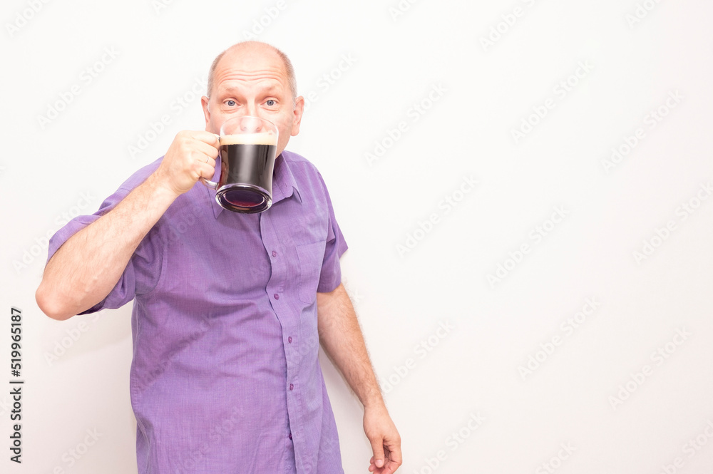 Caucasian man is happy, drinking dark beer from a beer mug. Caucasian man is happy, drinking dark beer from a beer mug.