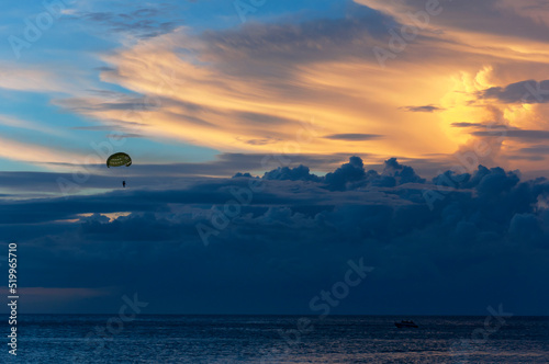 Beautiful bright sunset with colored clouds in the sky over the sea, ocean. Silhouette boat in the sea, lush clouds. Summer tropical natural background. Travel concept. Thailand, Phuket island