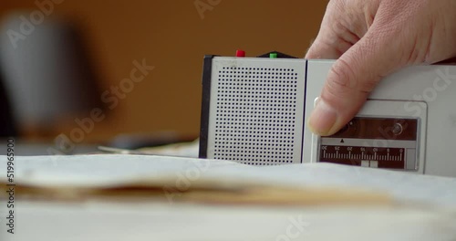 The person places the dictaphone on the documents and presses the red button to record
