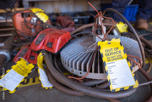 Safety workplaces yellow out of service tag attached on faulty damage defect unsafe to use of spot light at construction site Perth, Australia photo