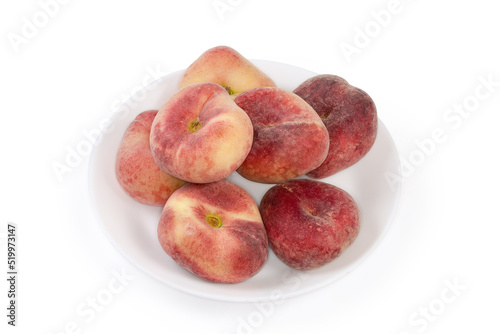 Flat peaches on the white dish on a white background photo