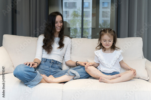 Mom and daughter have fun happily play and relax at home on the couch. Free time with children, upbringing, home comfort, parental relationship concept.