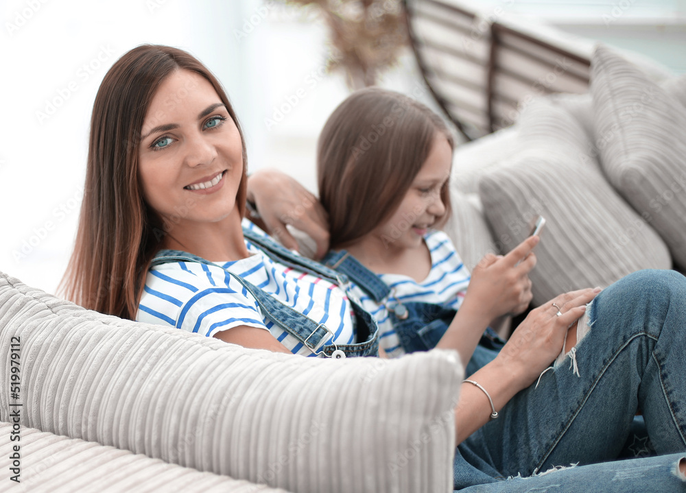 mother and daughter sitting on a comfortable sofa mother and daughter sitting on a comfortable sofa