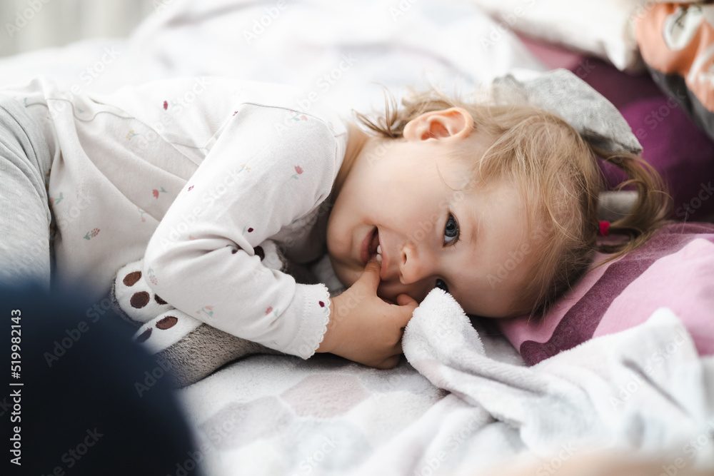 happy toddler girl in bed at home - obrazy, fototapety, plakaty 