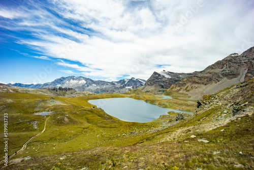 Excursion on the Gran Paradiso in the Alps. Walk in immense valleys and very high peaks above 3000m. Glacial lakes with crystal clear water and green meadows. The peaks crowned by huge rocks.