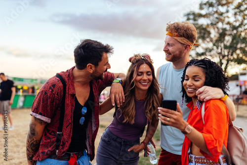 Group of friends going to music festival and using phone