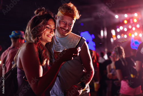 Couple using cellphone at music festival