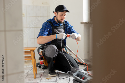 Connecting cables with a plug, extension cord plugging in construction equipment, breakdown, short circuit in house during renovation experienced man in field of electricity repairs electrical.