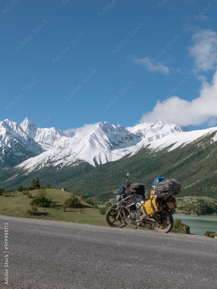 Touring motorcycle and snow covered mountains