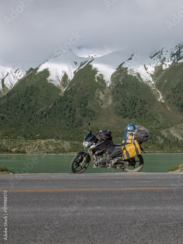 Touring motorcycle and snow covered mountains