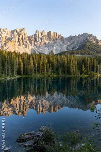 Splendid view of Lake Carezza in South Tyrol. The mountains and the forest are perfectly reflected on the lake, a suggestive image. A dream place for a relaxing holiday in nature.