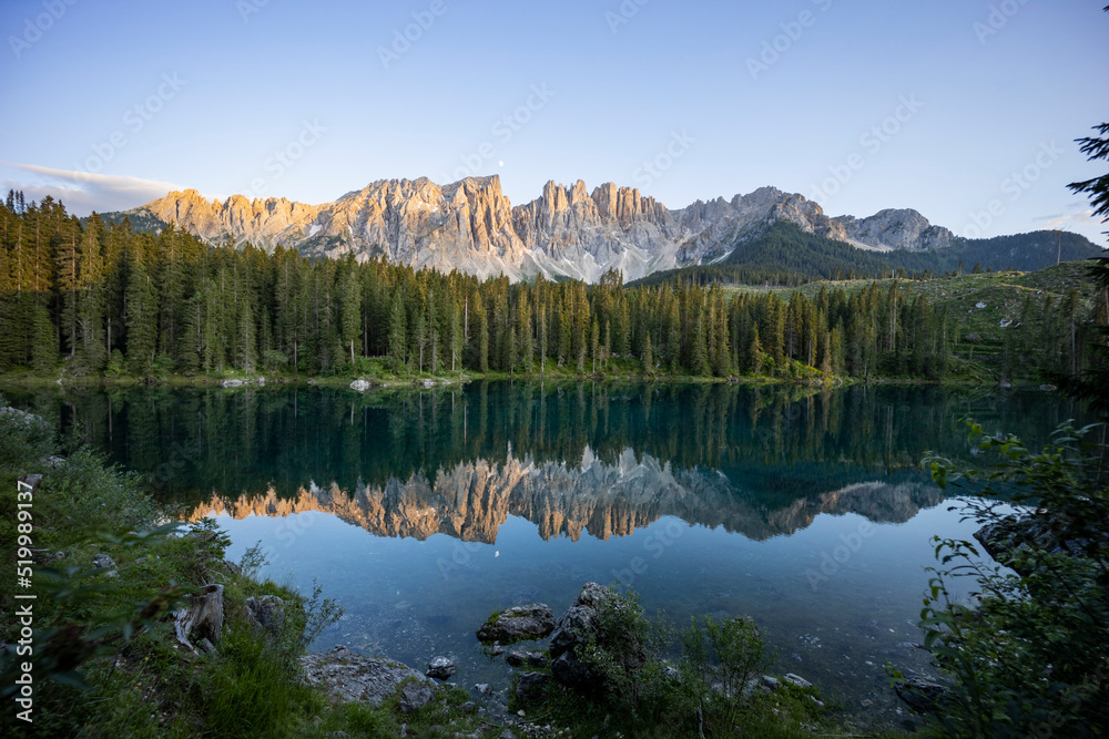 Splendid view of Lake Carezza in South Tyrol. The mountains and the forest are perfectly reflected on the lake, a suggestive image. A dream place for a relaxing holiday in nature.