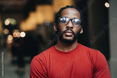 A portrait of young black man in red t-shirt and eyeglasses