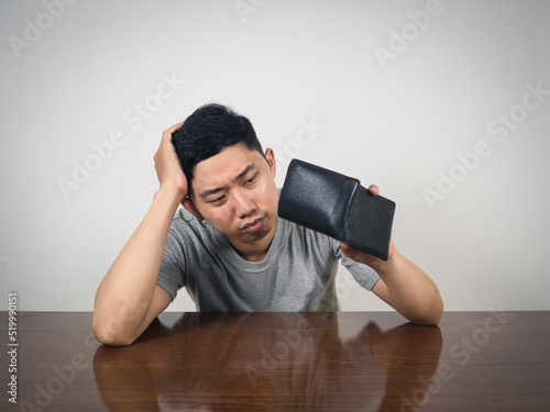 Poor man strain with no money hold wallet at table