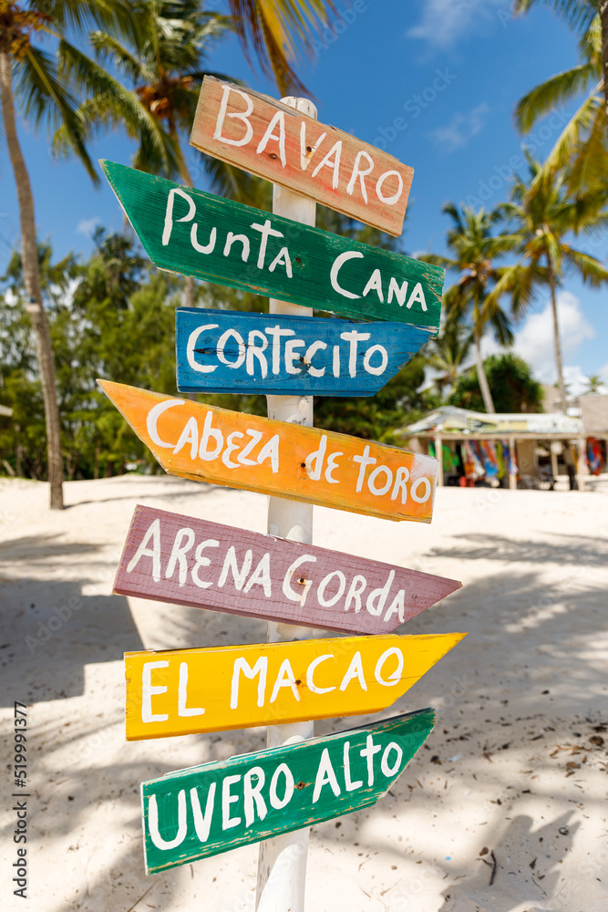 07.24.2022. Dominican Republic Bavaro Punta cana provinces La Altagracia. Wooden pillar with signposts directions - obrazy, fototapety, plakaty 