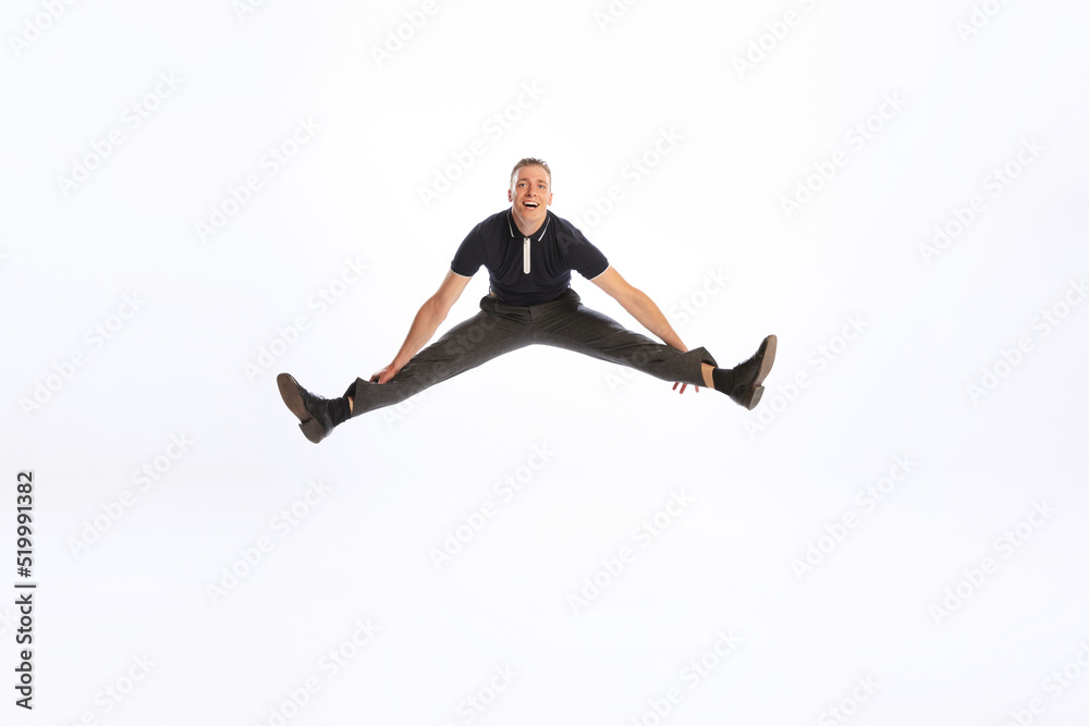 Portrait of young man in stylish black outfit posing isolated over white studio background. Jumping in a twine