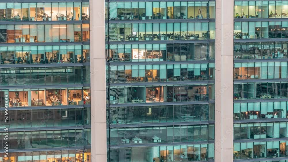Big glowing windows in modern office and residential buildings day to night transition timelapse, in rows of windows light turning on and shines. End of the working day Big glowing windows in modern office and residential buildings day to night transition timelapse, in rows of windows light turning on and shines. End of the working day