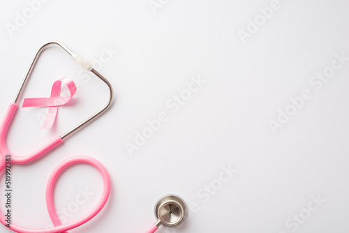 Breast cancer awareness concept. Top view photo of pink silk ribbon and stethoscope on isolated white background with copyspace