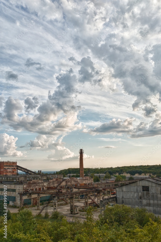 Old industrial plant with a beautiful sky. Clouds swirl in the sky. Abandoned factory. High-quality photo