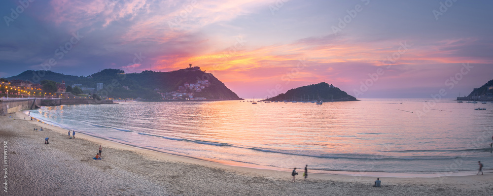 Obraz premium Nice beach with the old town of San Sebastian, Spain at gorgeous sunset