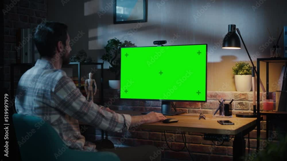 Creative Specialist Chatting on Video Call on Desktop Computer with Monitor with Green Screen Mock Up at Home Living Room. Freelancer Calling Colleagues Over Internet on Social Network Conference App. Creative Specialist Chatting on Video Call on Desktop Computer with Monitor with Green Screen Mock Up at Home Living Room. Freelancer Calling Colleagues Over Internet on Social Network Conference App.