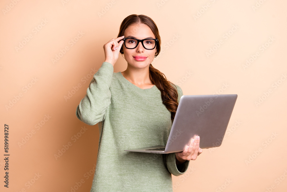 Photo of pretty confident girl dressed green pullover arm eyewear typing modern device isolated beige color background Photo of pretty confident girl dressed green pullover arm eyewear typing modern device isolated beige color background