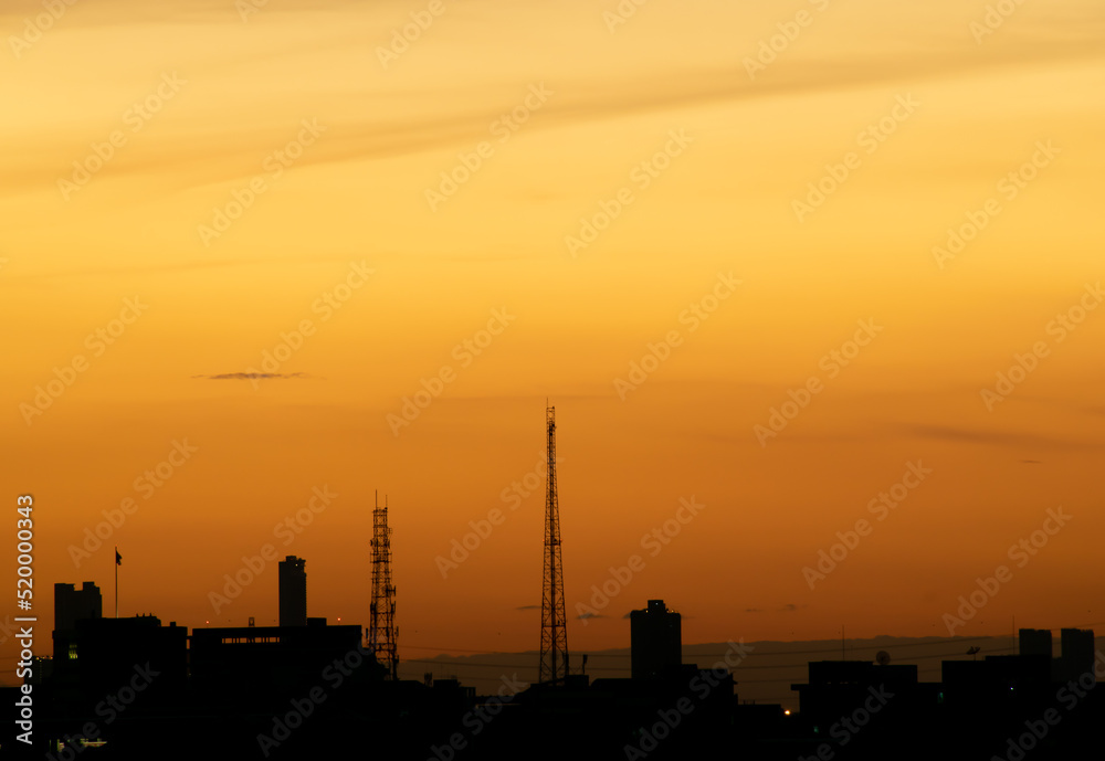 Gives a warm feeling,sunset behind the city building,silhouette city tall buildings,building silhouette again beautiful sky background and freedom concept.