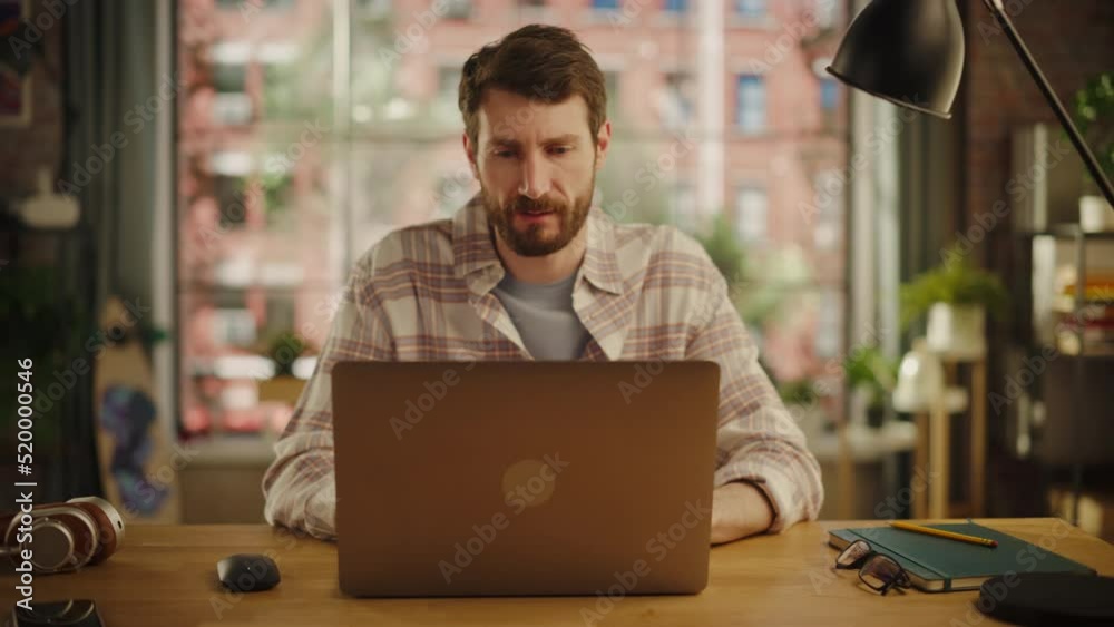 Creative Man is Happy About a Great Solution He Arrived After Careful Consideration. Project Manager Working from Home, Writing a Marketing Project on Laptop Computer. Zoom Out Shot. Creative Man is Happy About a Great Solution He Arrived After Careful Consideration. Project Manager Working from Home, Writing a Marketing Project on Laptop Computer. Zoom Out Shot.