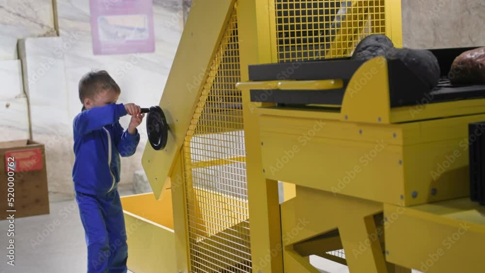 children education, little smart boy playing on stone mining simulator, which demonstrates mining of minerals in museum children education, little smart boy playing on stone mining simulator, which demonstrates mining of minerals in museum