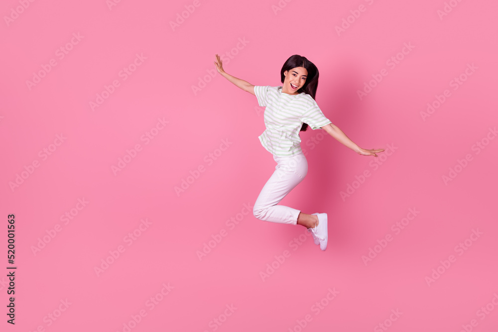 Full length photo of excited pretty korean girl jump shopping sales banner dressed stylish white t-shirt isolated on pink color background Full length photo of excited pretty korean girl jump shopping sales banner dressed stylish white t-shirt isolated on pink color background